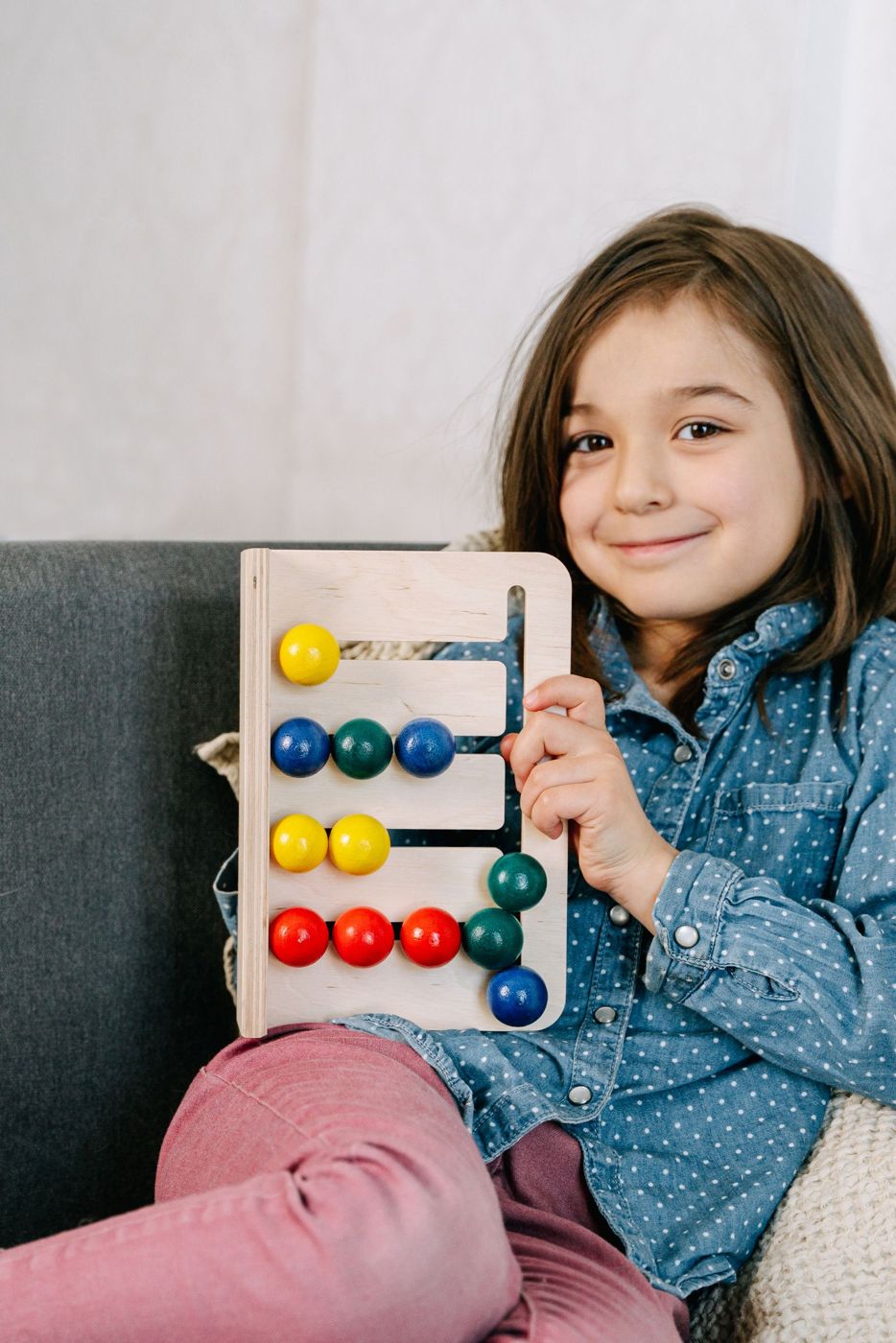 A smiling student holding her abacus